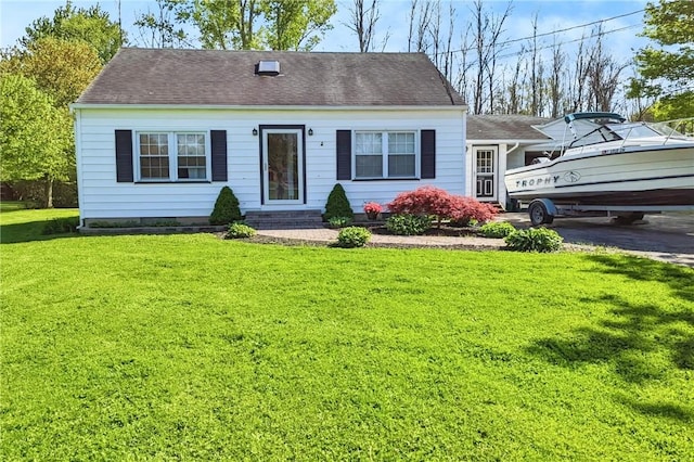 view of front facade with a front lawn and a shingled roof