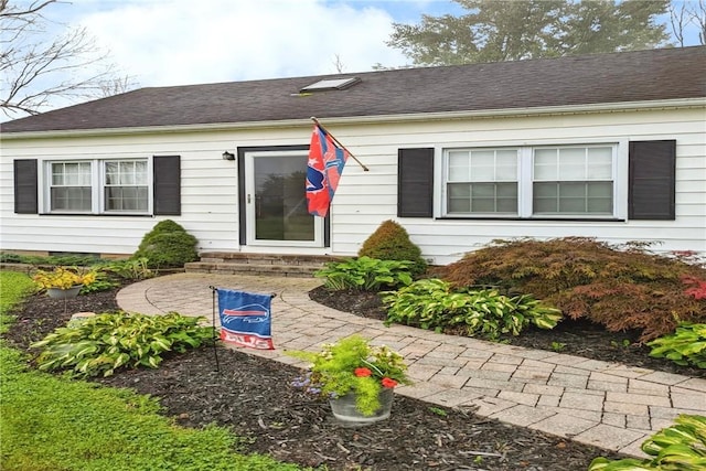 entrance to property with roof with shingles