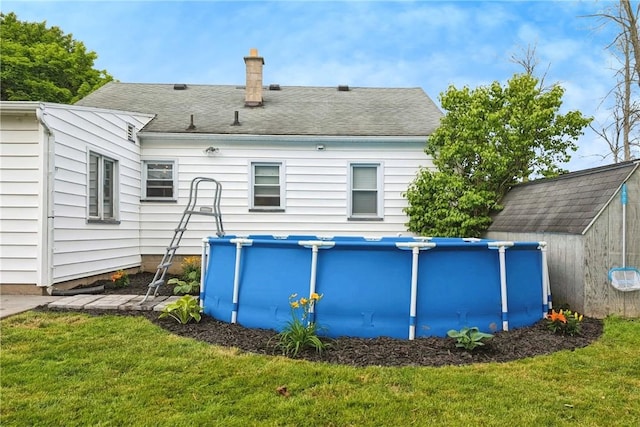 outdoor pool with an outbuilding and a lawn