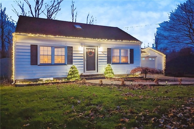 view of front of home with a detached garage and a front yard