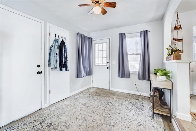 foyer entrance featuring ceiling fan and baseboards