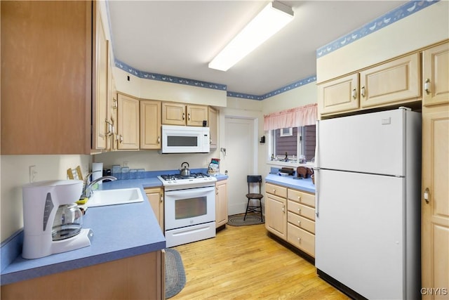 kitchen with light wood-type flooring, white appliances, light brown cabinets, and a sink