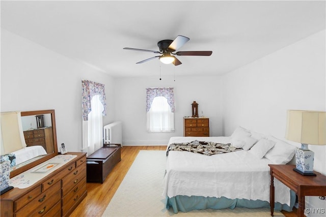 bedroom featuring radiator, a ceiling fan, and light wood-style floors