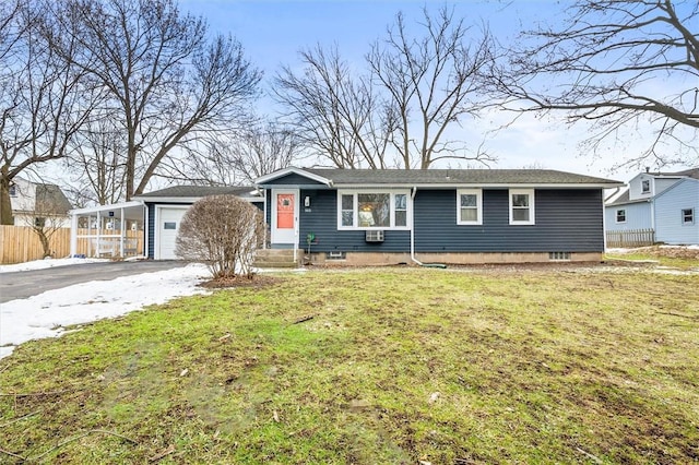 ranch-style home with aphalt driveway, a garage, fence, and a front lawn