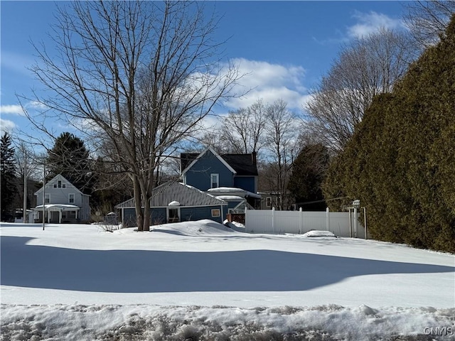 yard layered in snow featuring fence