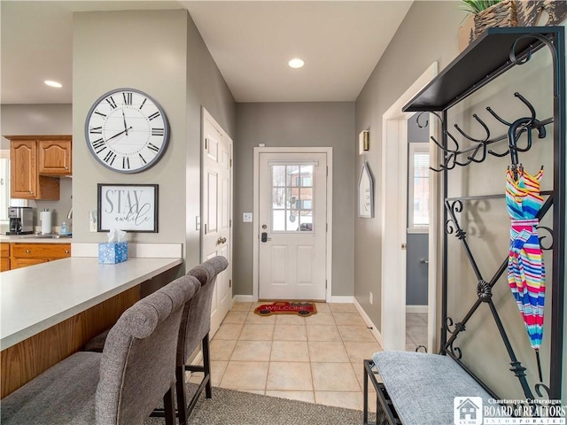 doorway to outside featuring recessed lighting, baseboards, and light tile patterned flooring