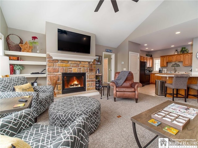 living area with a stone fireplace, recessed lighting, light colored carpet, a ceiling fan, and vaulted ceiling