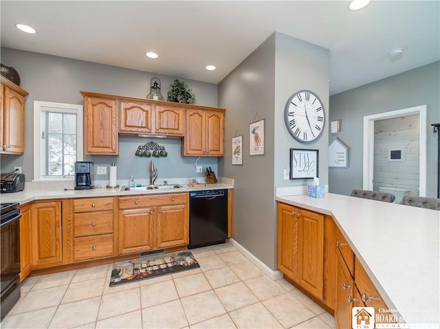 kitchen featuring black appliances, a sink, light countertops, and recessed lighting