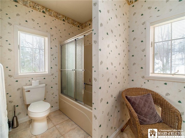 full bath with tile patterned flooring, toilet, baseboards, combined bath / shower with glass door, and wallpapered walls