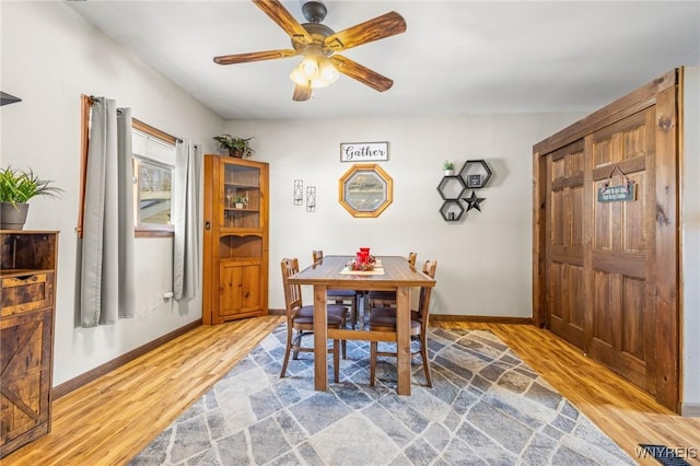 dining area with light wood-style flooring, baseboards, and ceiling fan