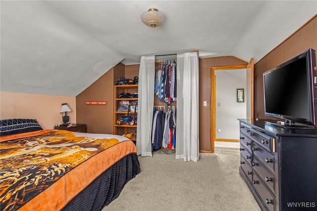 bedroom featuring vaulted ceiling, a closet, baseboards, and light colored carpet