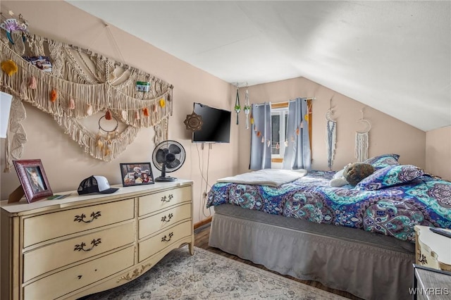 bedroom featuring lofted ceiling and wood finished floors