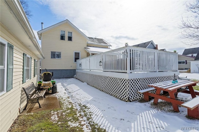 snow covered house with a deck