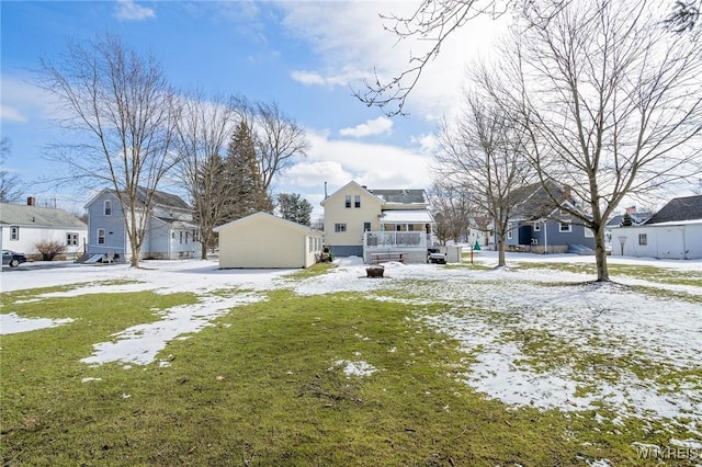 snowy yard featuring an outbuilding and a residential view