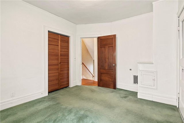 unfurnished bedroom with visible vents, baseboards, a closet, carpet, and crown molding