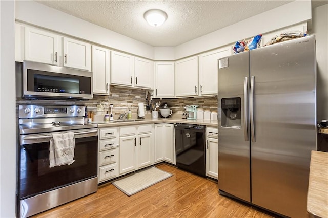 kitchen featuring stainless steel appliances, light wood-type flooring, light countertops, and white cabinetry