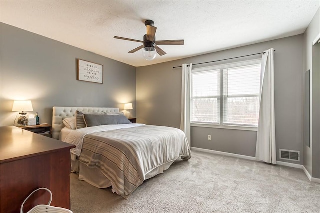 bedroom featuring baseboards, visible vents, ceiling fan, carpet, and a textured ceiling