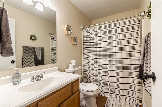 full bathroom with a textured ceiling, a shower with shower curtain, vanity, and toilet