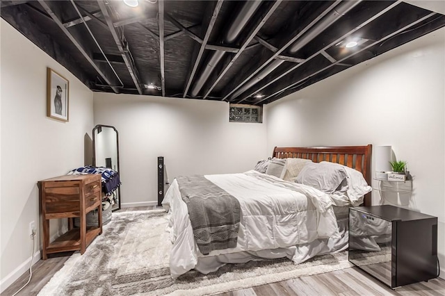 bedroom featuring wood finished floors and baseboards