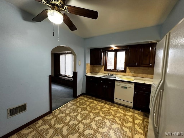 kitchen with light countertops, visible vents, decorative backsplash, a sink, and white appliances