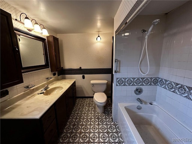 bathroom with bathing tub / shower combination, toilet, vanity, tile patterned flooring, and wallpapered walls