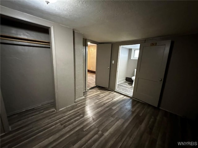 unfurnished bedroom with dark wood-style flooring and a textured ceiling