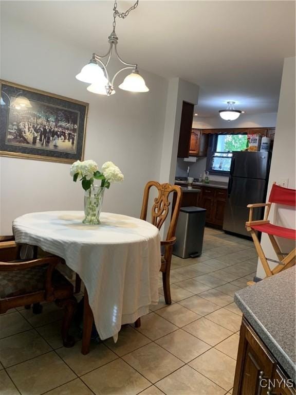 dining area featuring a chandelier and light tile patterned flooring