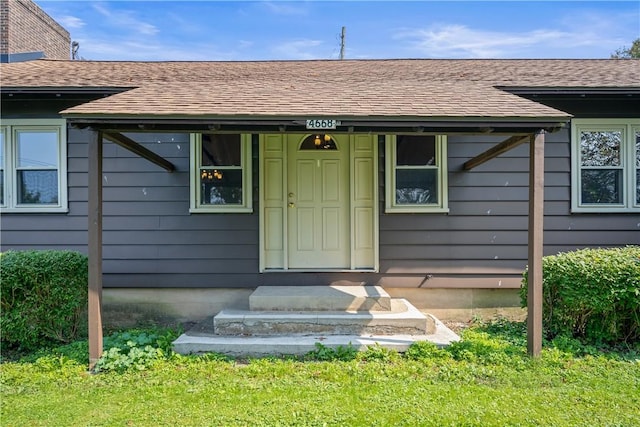 view of exterior entry with a shingled roof