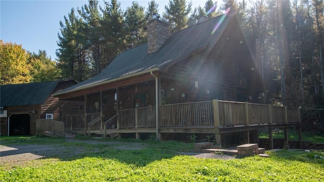 rear view of property with a chimney and log exterior