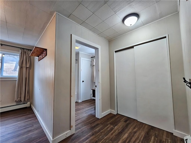 hall featuring baseboards, baseboard heating, and dark wood finished floors