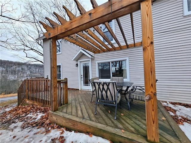 wooden deck with outdoor dining area and a pergola