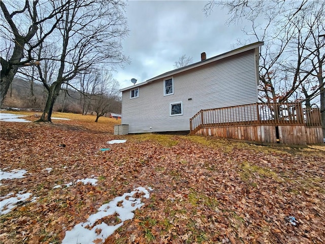 rear view of house featuring a chimney and a wooden deck