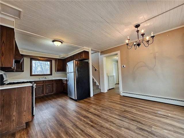 kitchen featuring range with gas cooktop, a baseboard radiator, light countertops, visible vents, and freestanding refrigerator