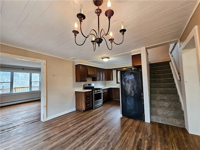 kitchen with dark brown cabinetry, freestanding refrigerator, light countertops, a chandelier, and stainless steel range with gas stovetop