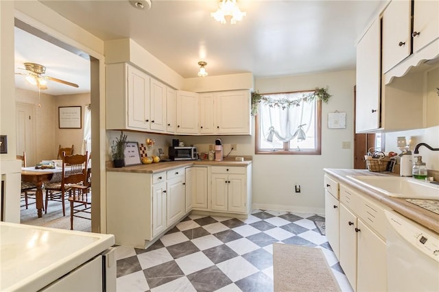 kitchen with ceiling fan, a sink, light countertops, dishwasher, and light floors