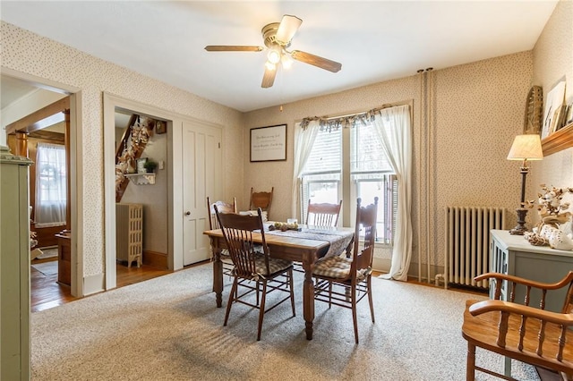 dining room featuring a healthy amount of sunlight, radiator heating unit, and wallpapered walls