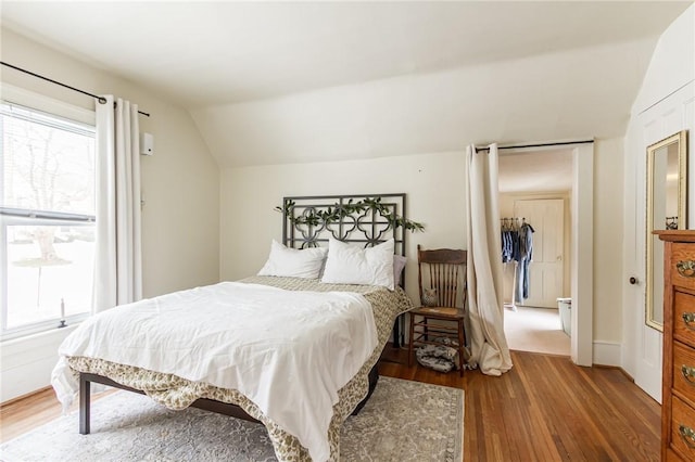 bedroom featuring vaulted ceiling and wood finished floors