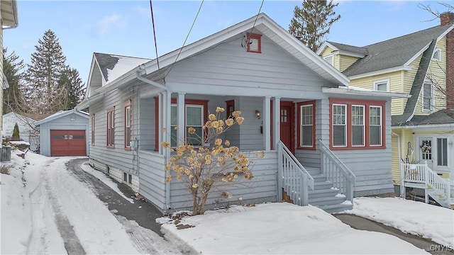 bungalow-style house with a garage and an outbuilding