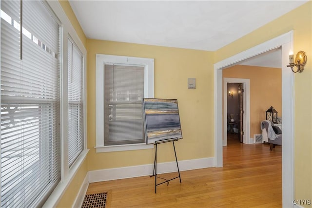 interior space featuring visible vents, baseboards, and wood finished floors