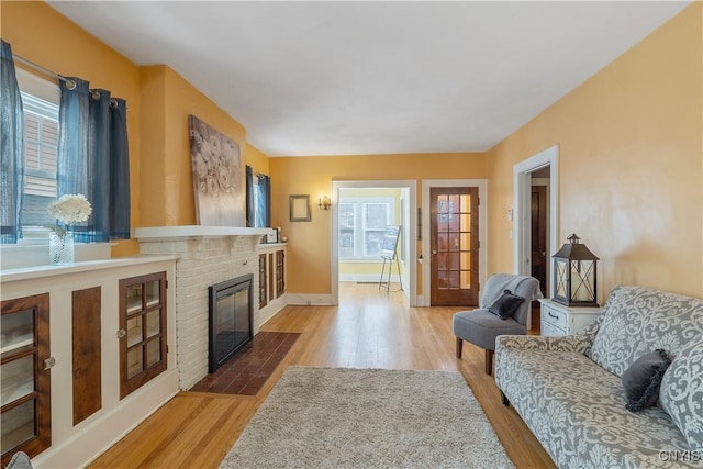 interior space with a fireplace, baseboards, and wood finished floors