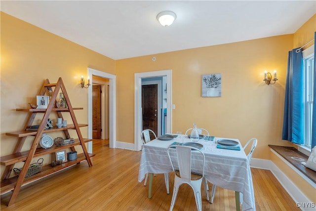 dining area with light wood-style flooring and baseboards