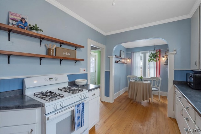 kitchen with arched walkways, black microwave, white cabinetry, white range with gas cooktop, and dark countertops