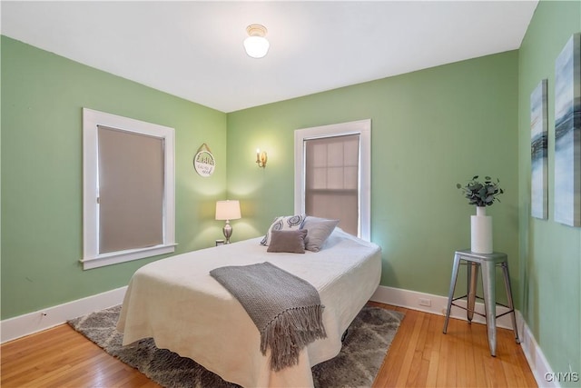 bedroom with hardwood / wood-style flooring and baseboards