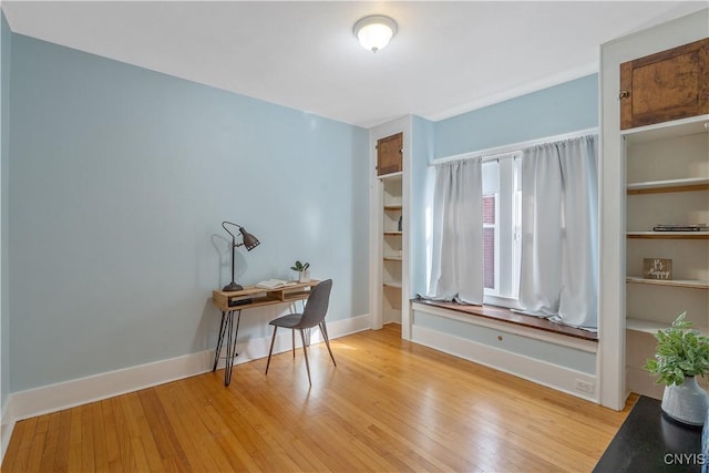 home office with light wood-type flooring and baseboards