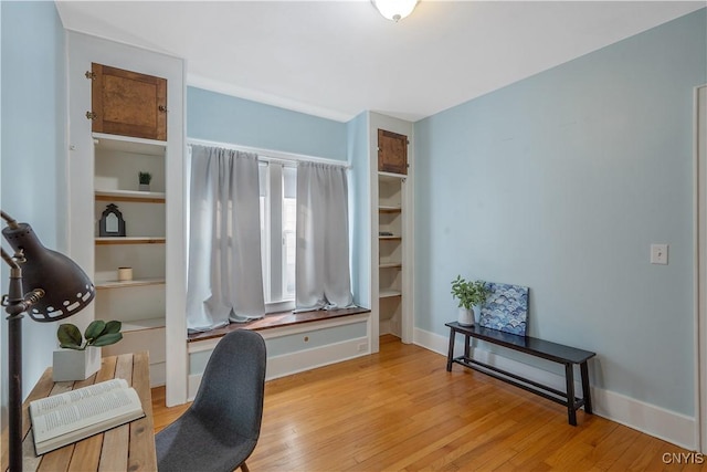 office area with light wood-style floors and baseboards