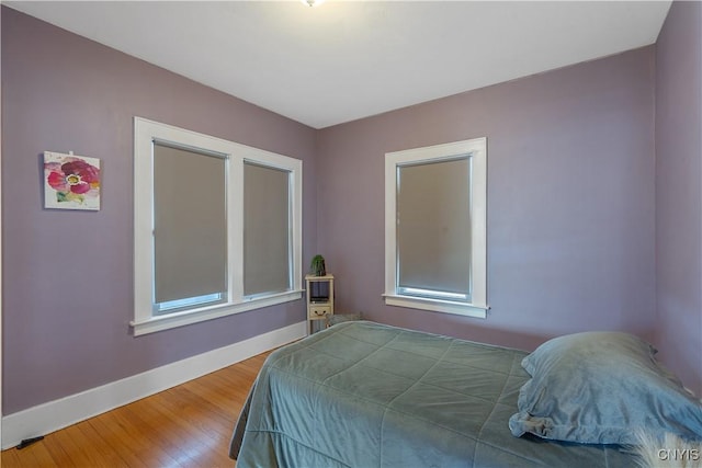 bedroom with baseboards and wood finished floors