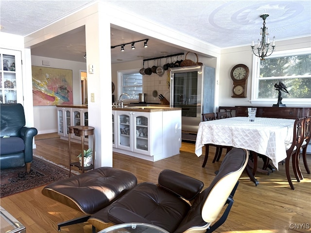 living room with a textured ceiling, a chandelier, and wood finished floors