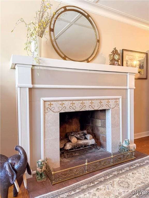 room details featuring ornamental molding, a tiled fireplace, and baseboards