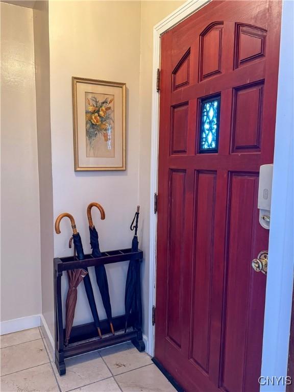 entrance foyer with light tile patterned flooring and baseboards