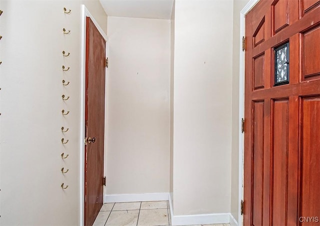 foyer entrance with baseboards and light tile patterned floors